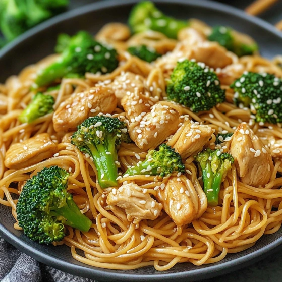 A bowl of noodles with broccoli and chicken.
