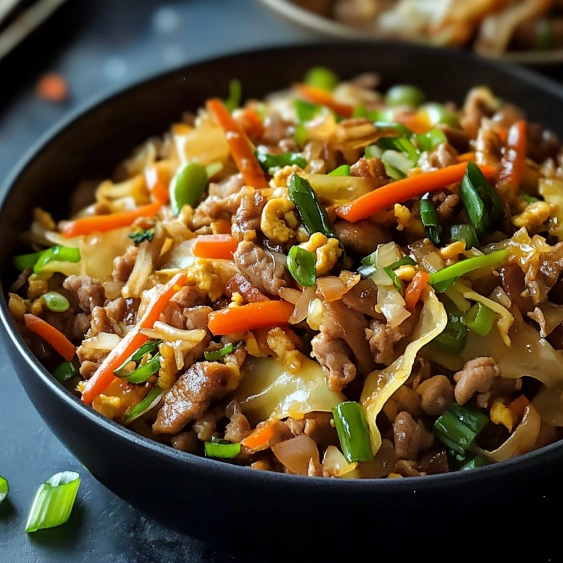 A bowl of stir fry with meat and vegetables.