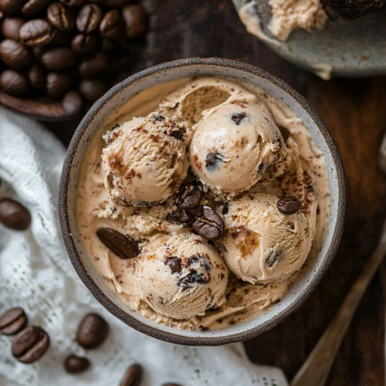 A bowl of ice cream with chocolate chips.