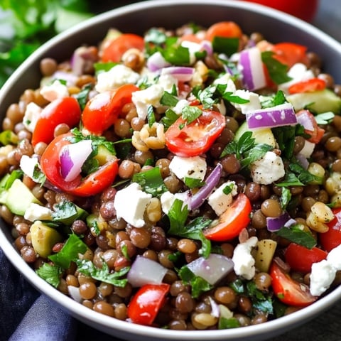 A bowl of food with tomatoes, cucumbers, and feta cheese.